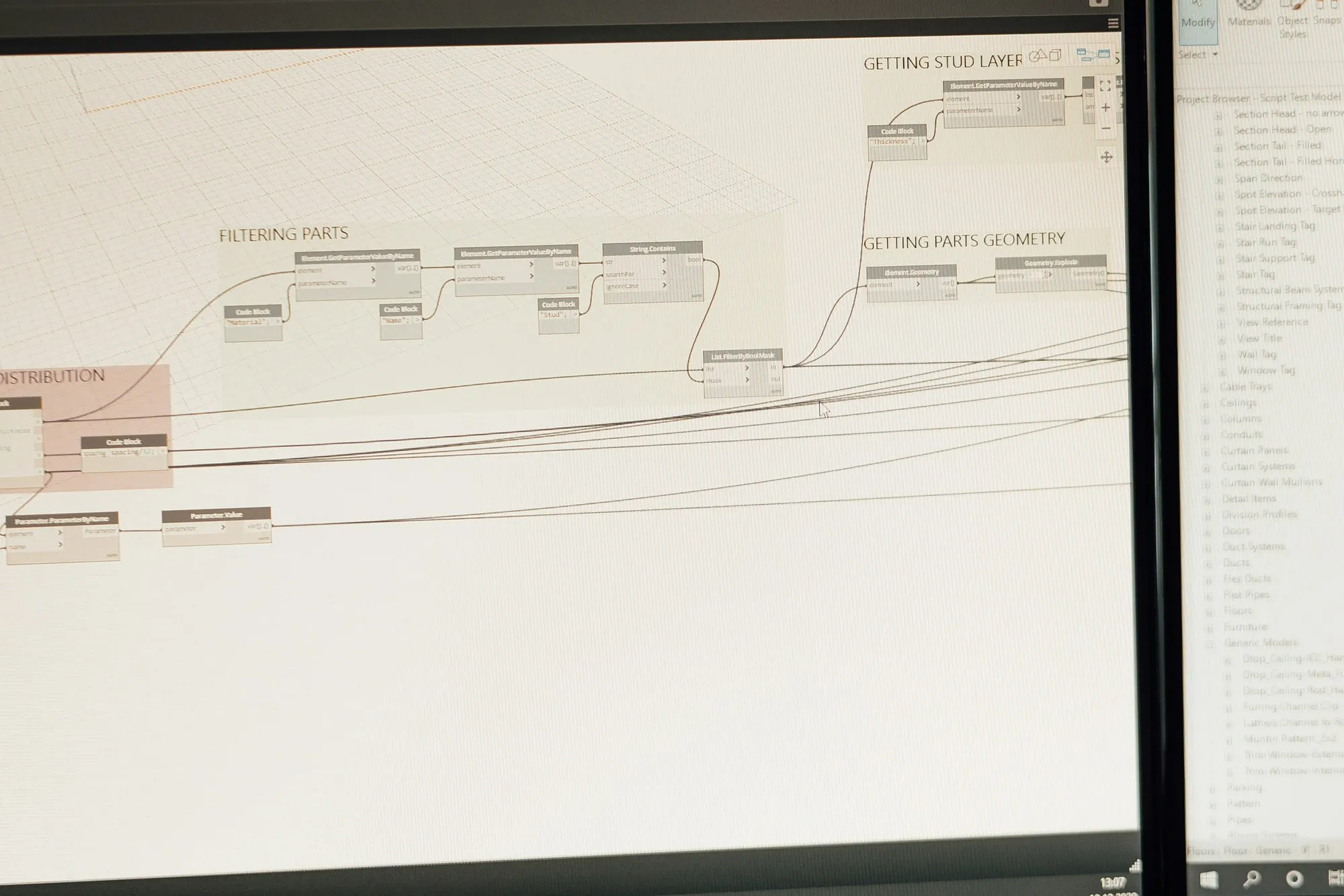 Monitor showing a Revit project browser and parametric script graph for a building model
