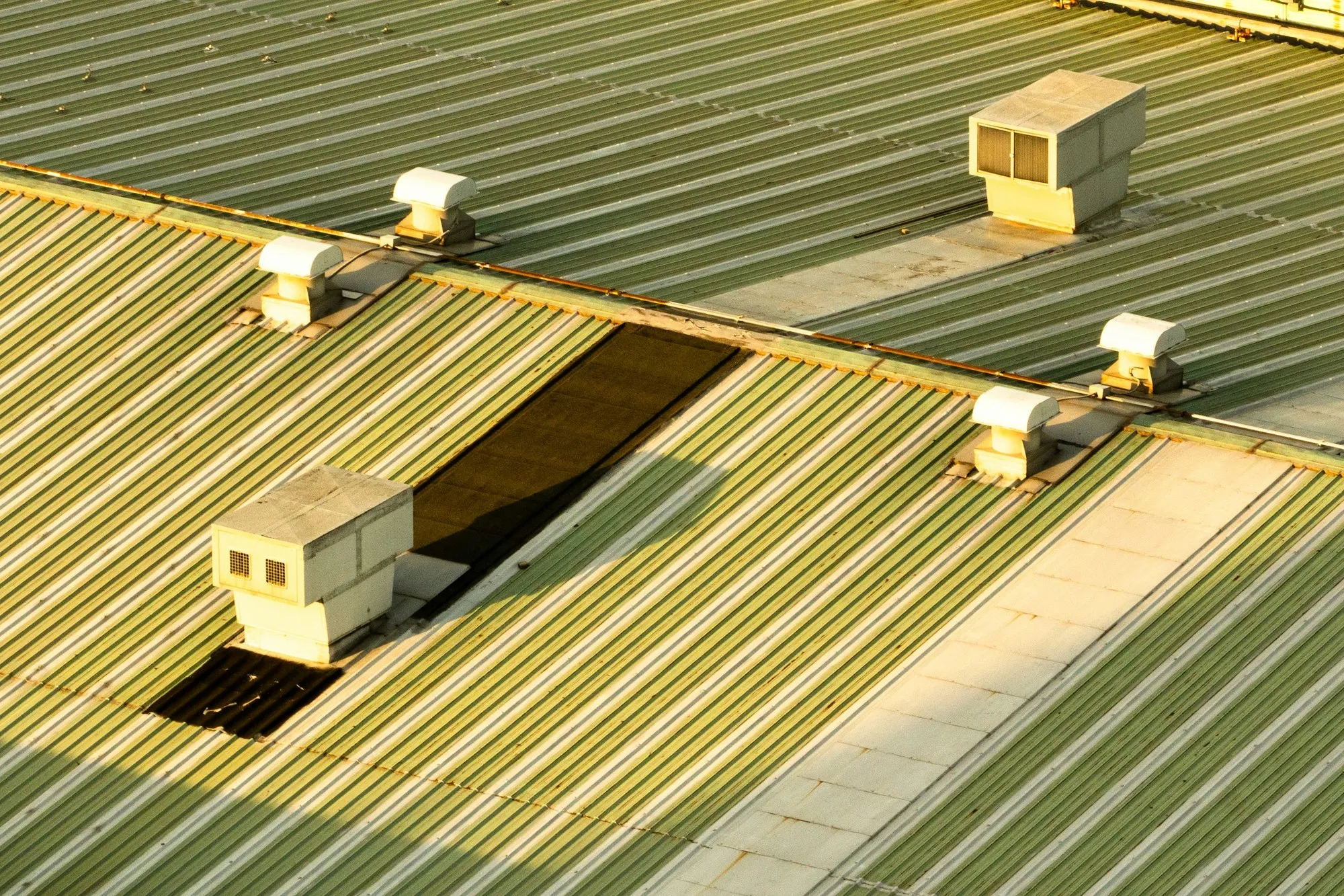Corrugated metal roof sheets with ventilation units and an open section