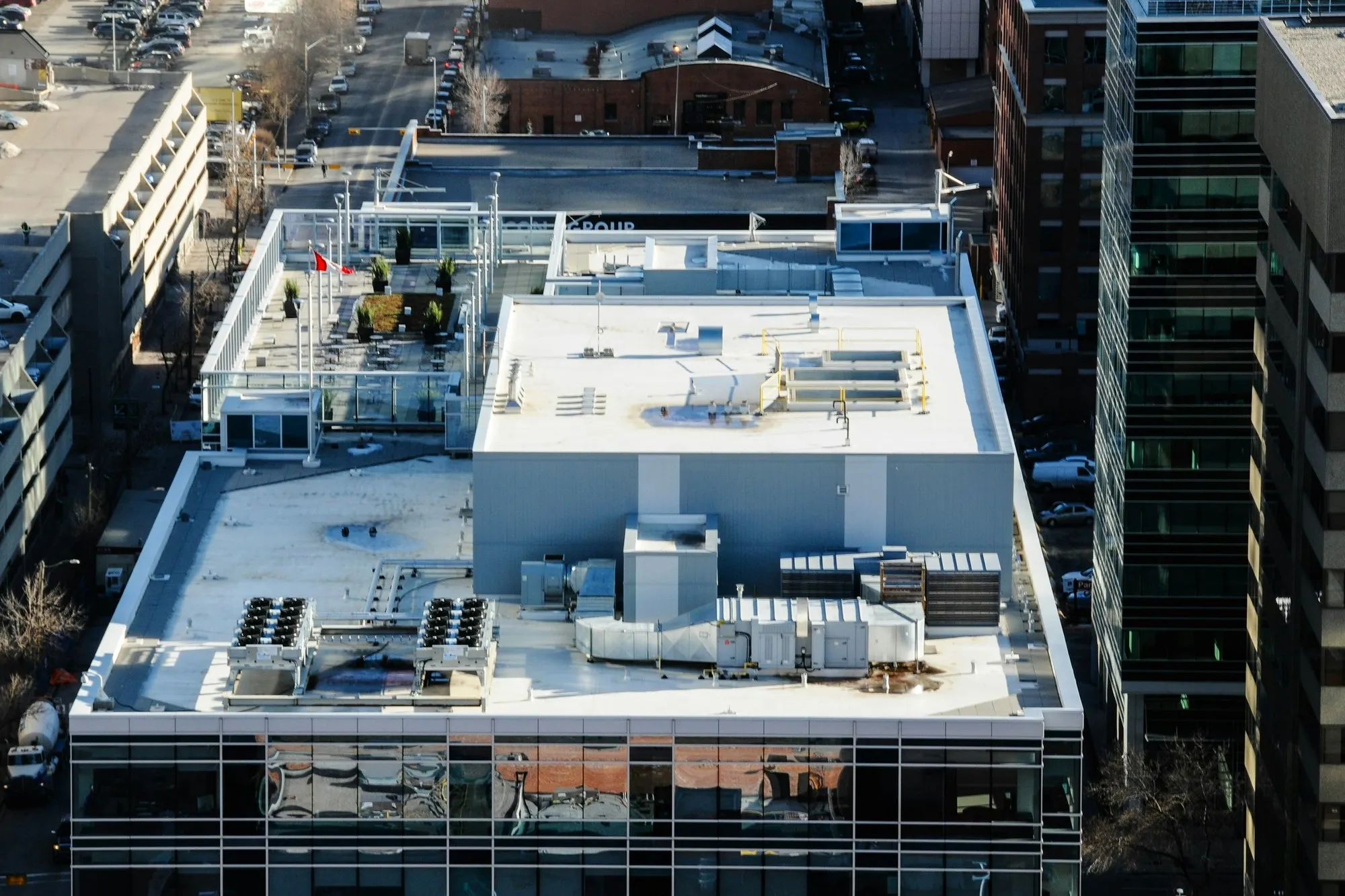 Flat office roof with plant and a small team, seen from above