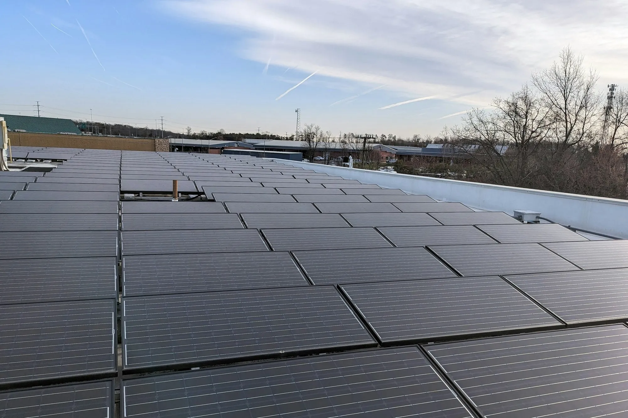 Rows of solar panels on a large flat commercial roof