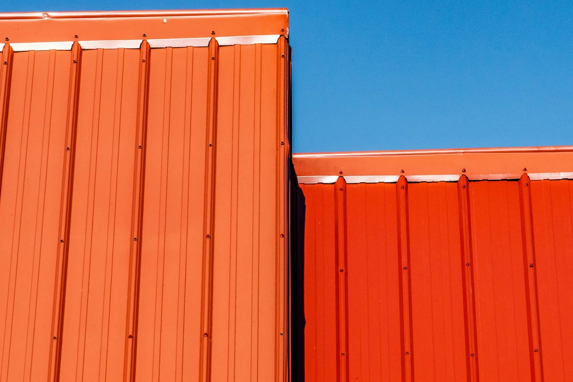 Orange standing-seam metal cladding on an industrial building