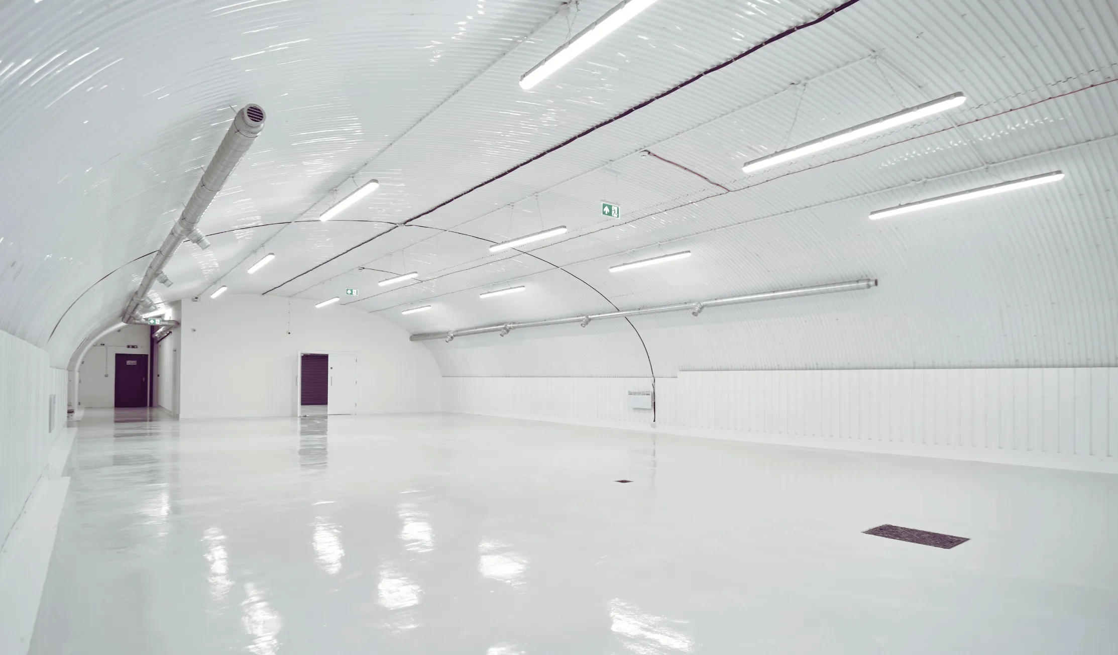 Fitted railway-arch warehouse with LED batten lighting, delivered by Craftex for Drake's in London