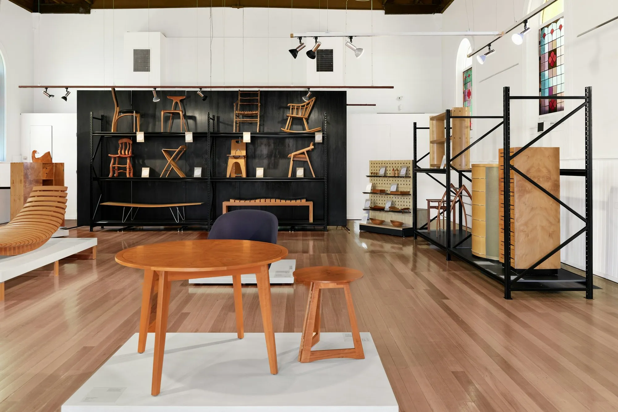 High-end furniture showroom in a converted period building with arched windows and roof timbers