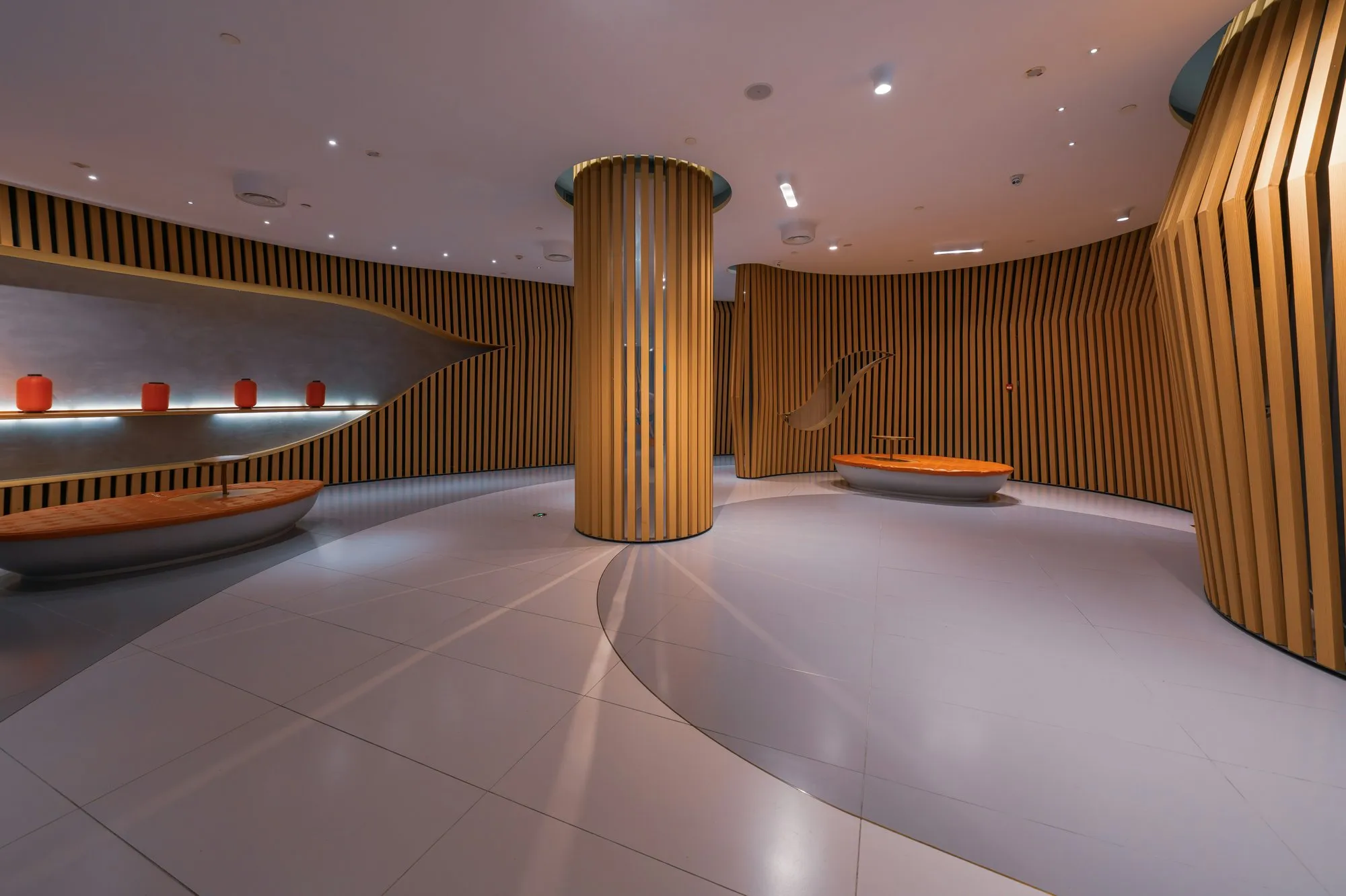 Boutique interior with curved timber-slat walls and warm cove lighting