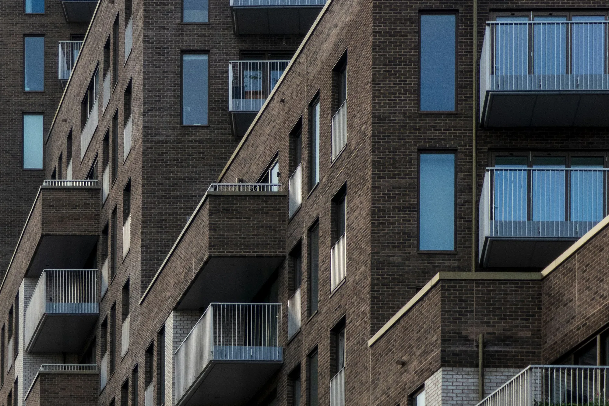 Dark brick apartment block with metal and glass balconies