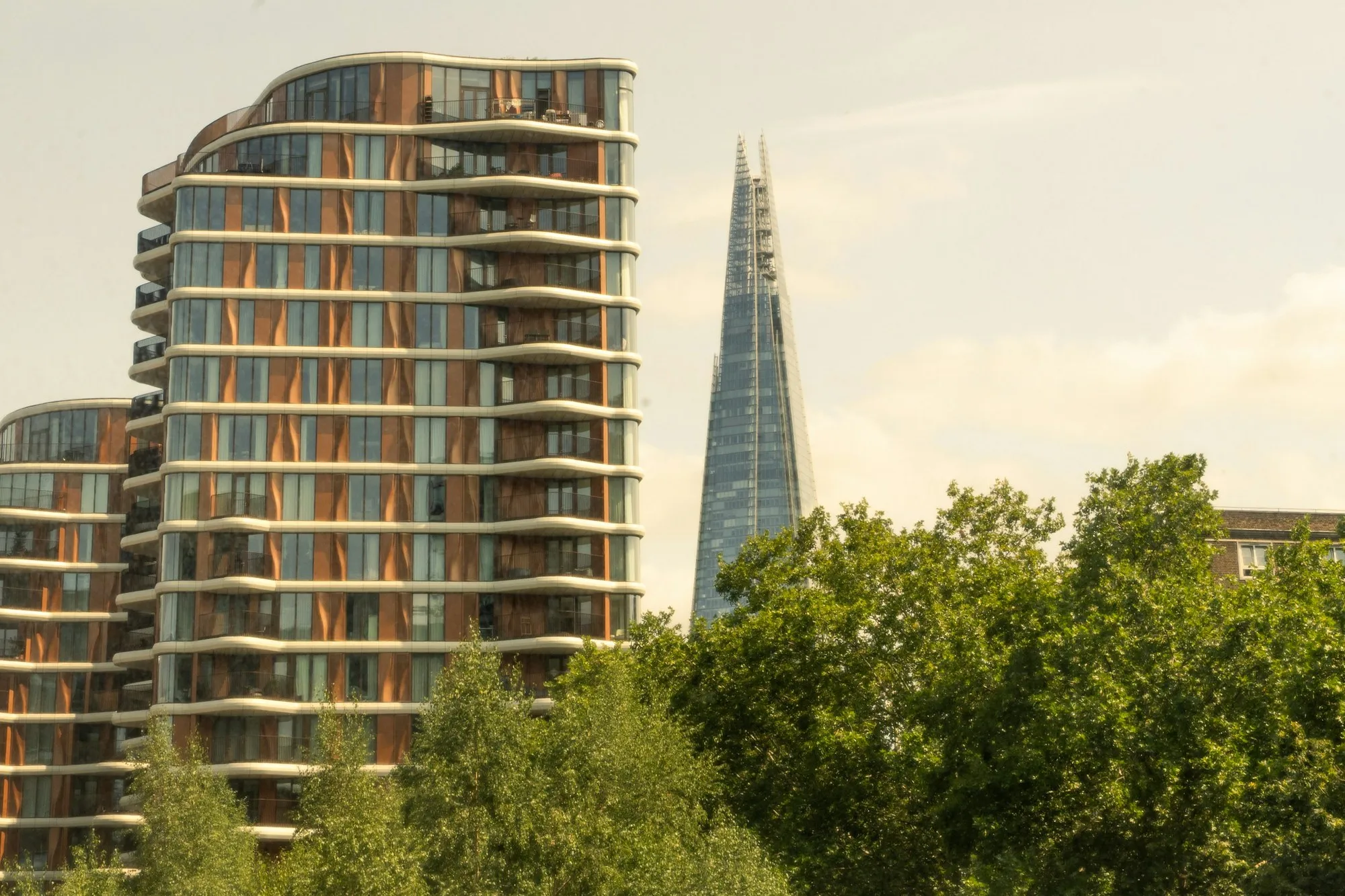 Modern curved-balcony apartment tower beside The Shard, London
