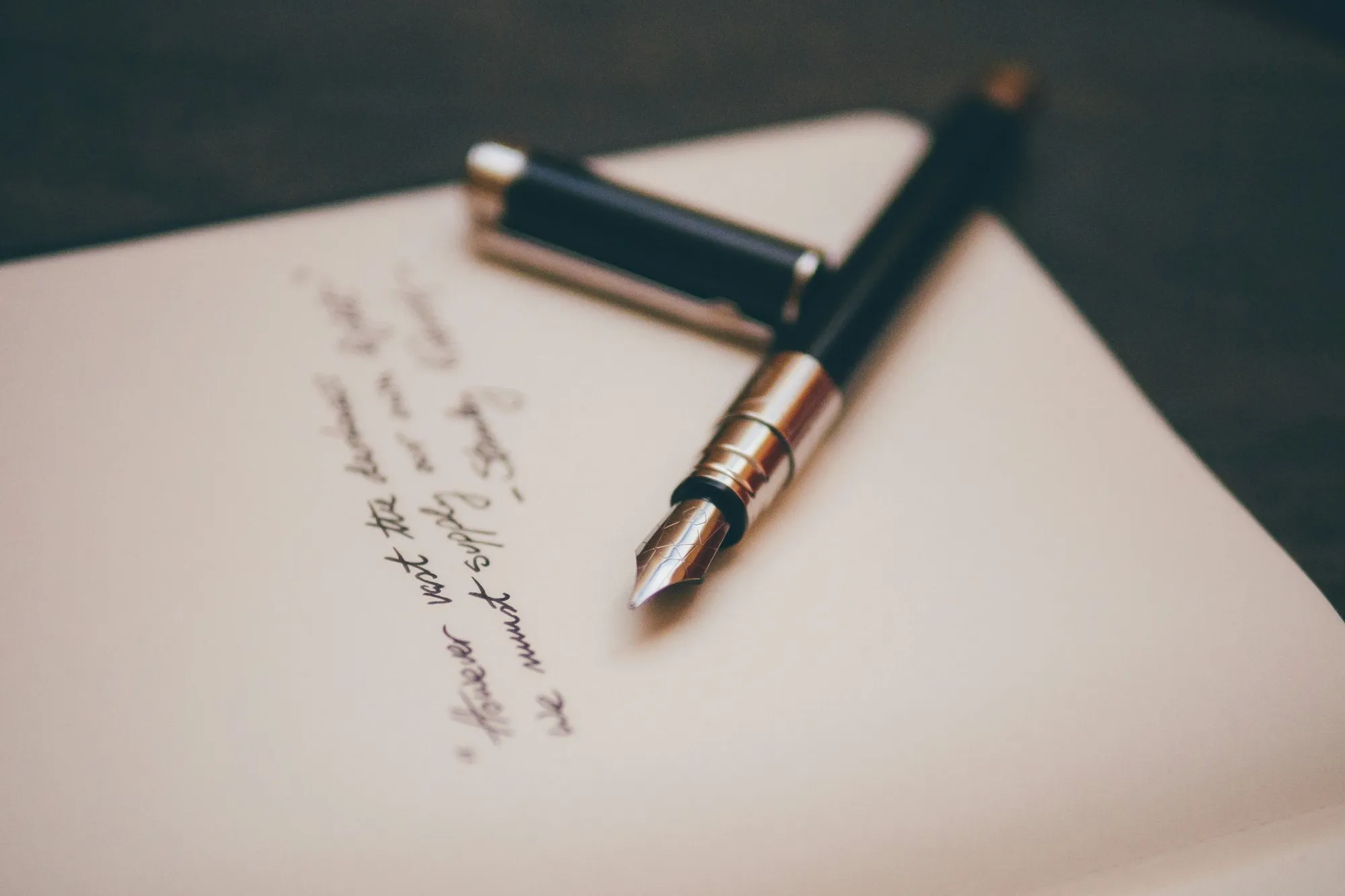 Black and silver fountain pen on cream paper with handwritten script, soft shallow focus