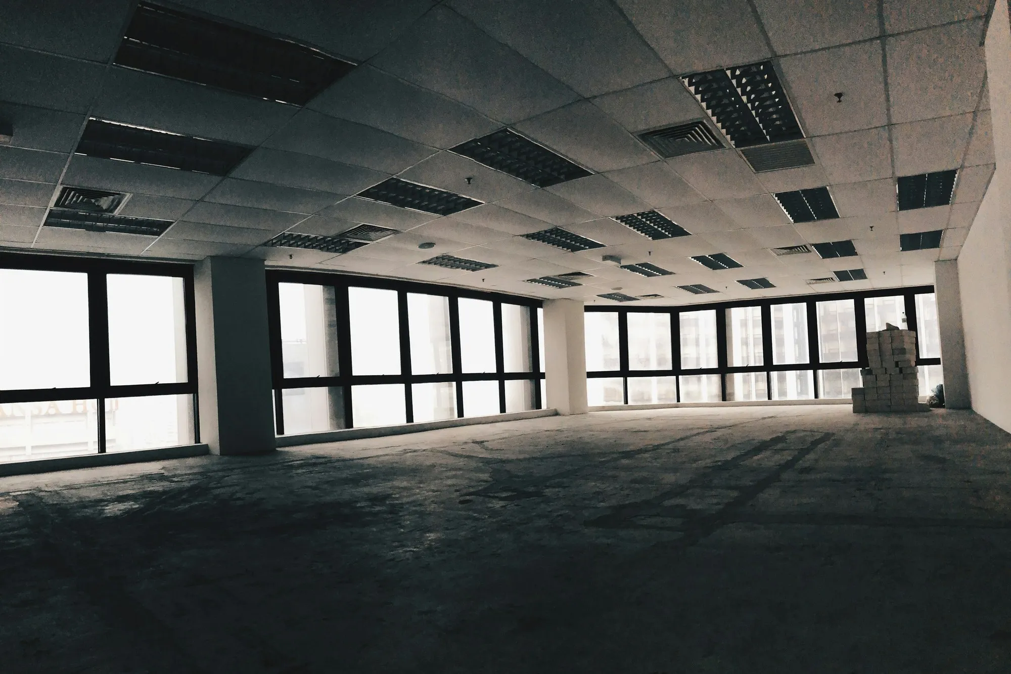 Empty office floor stripped to the ceiling grid with large windows