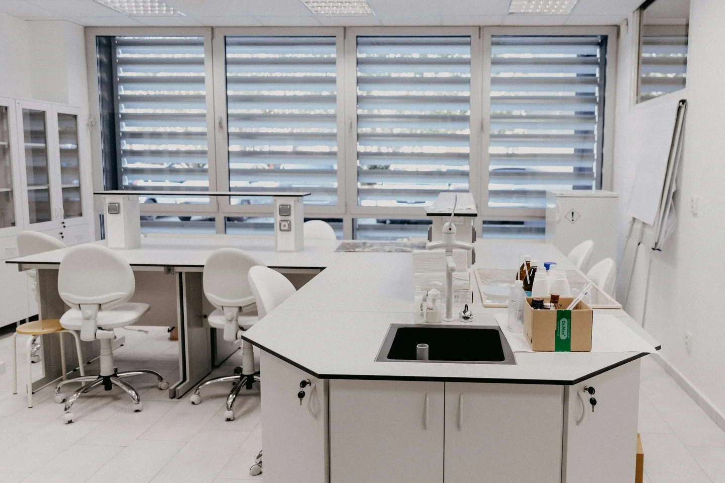 Bright white laboratory with island bench, sink and louvred windows