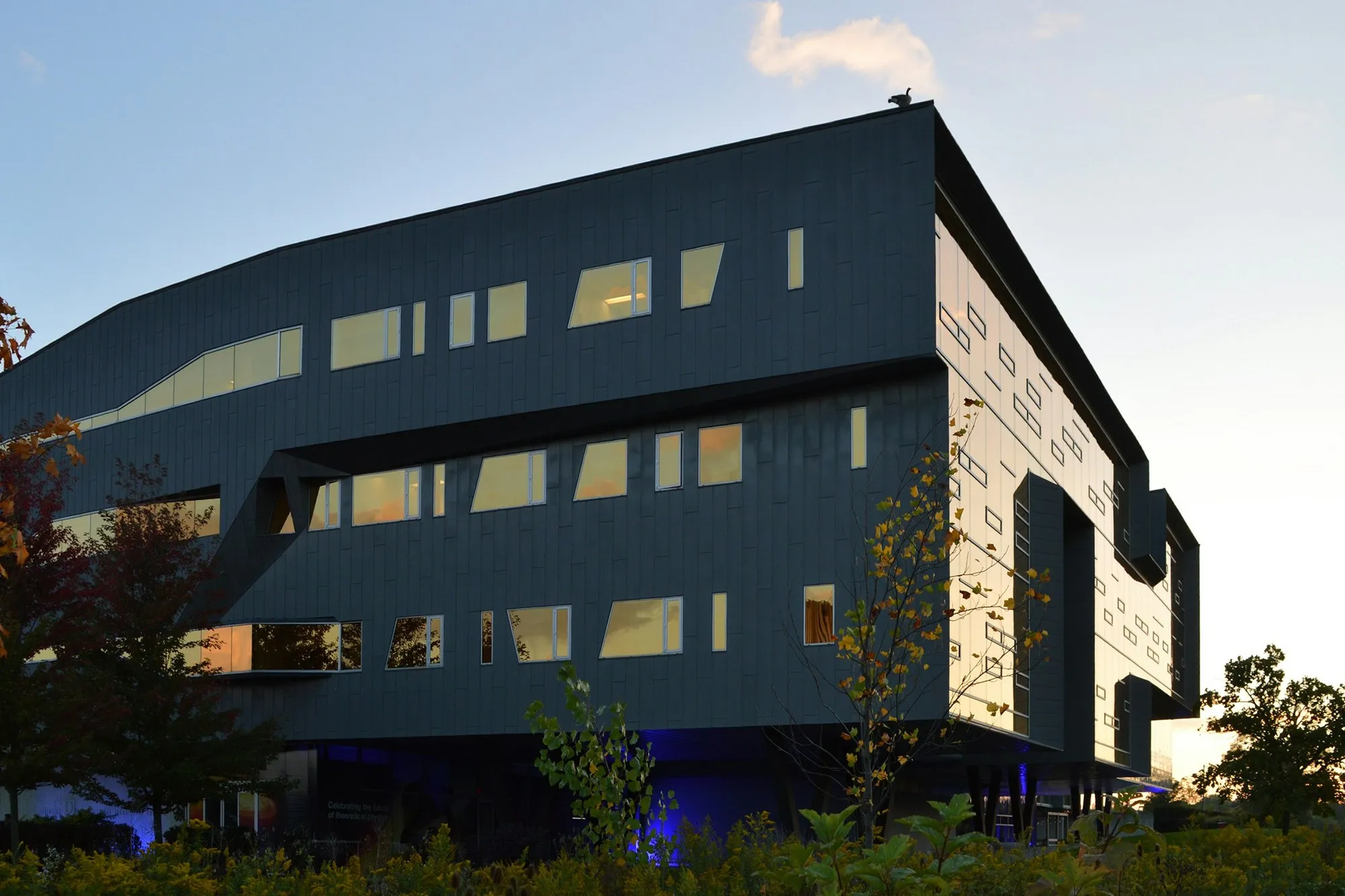 Modern dark-clad science building with glazing at dusk
