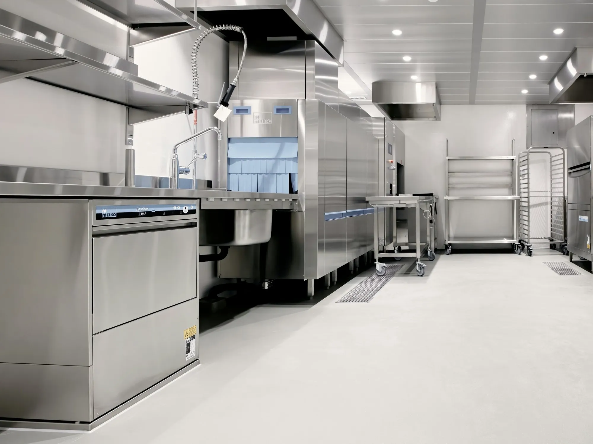 Commercial kitchen with stainless steel dishwashing line, canopy and racking