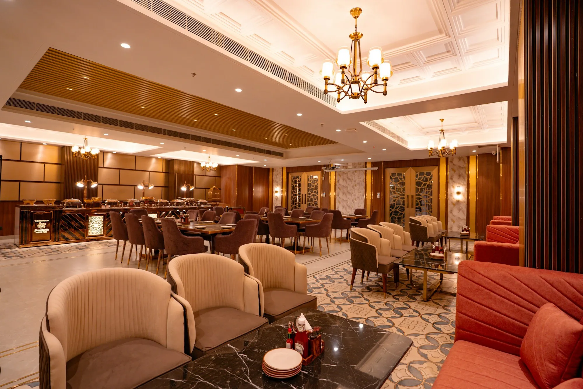 Luxury restaurant interior with velvet lounge seating, marble-topped tables and coffered ceiling lighting