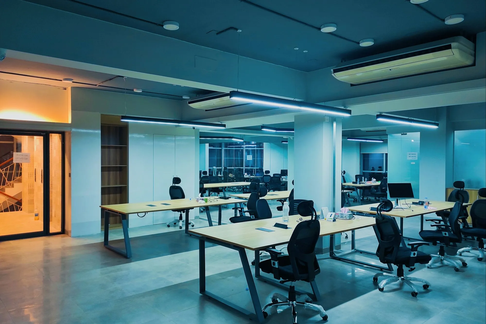 Working office with desks in use and ceiling services overhead