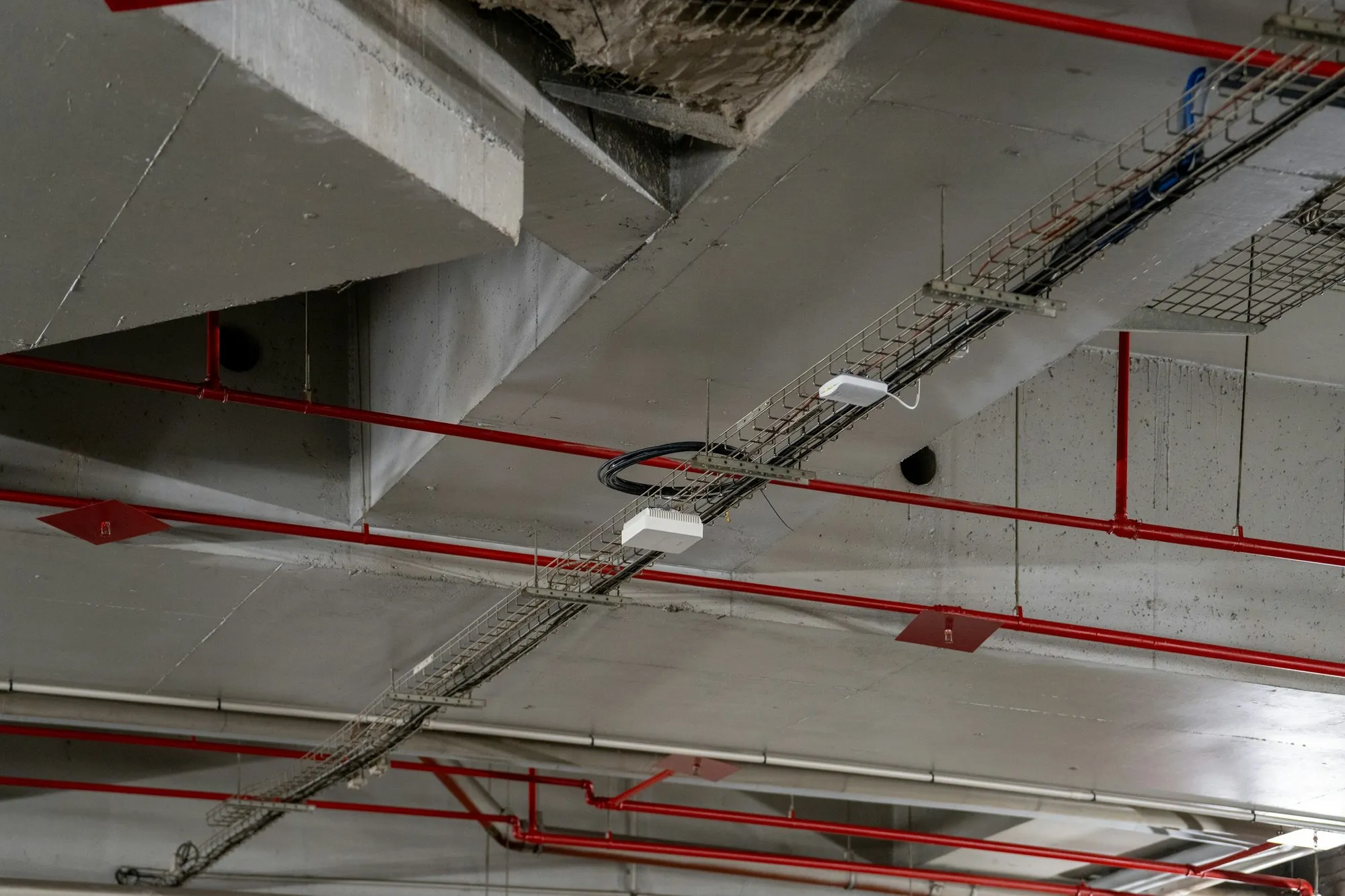 Exposed pipework and cable trays in a commercial ceiling void