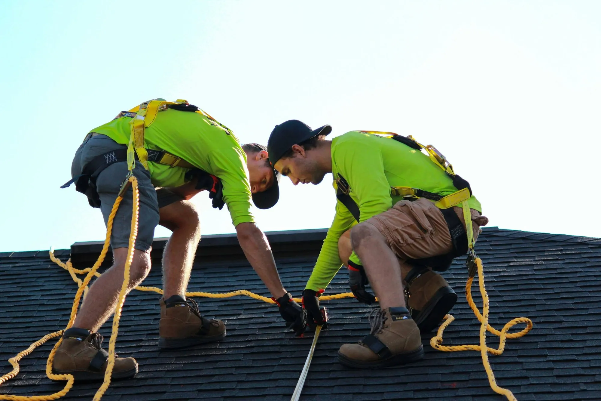 Two installers securing a roof before fitting panels