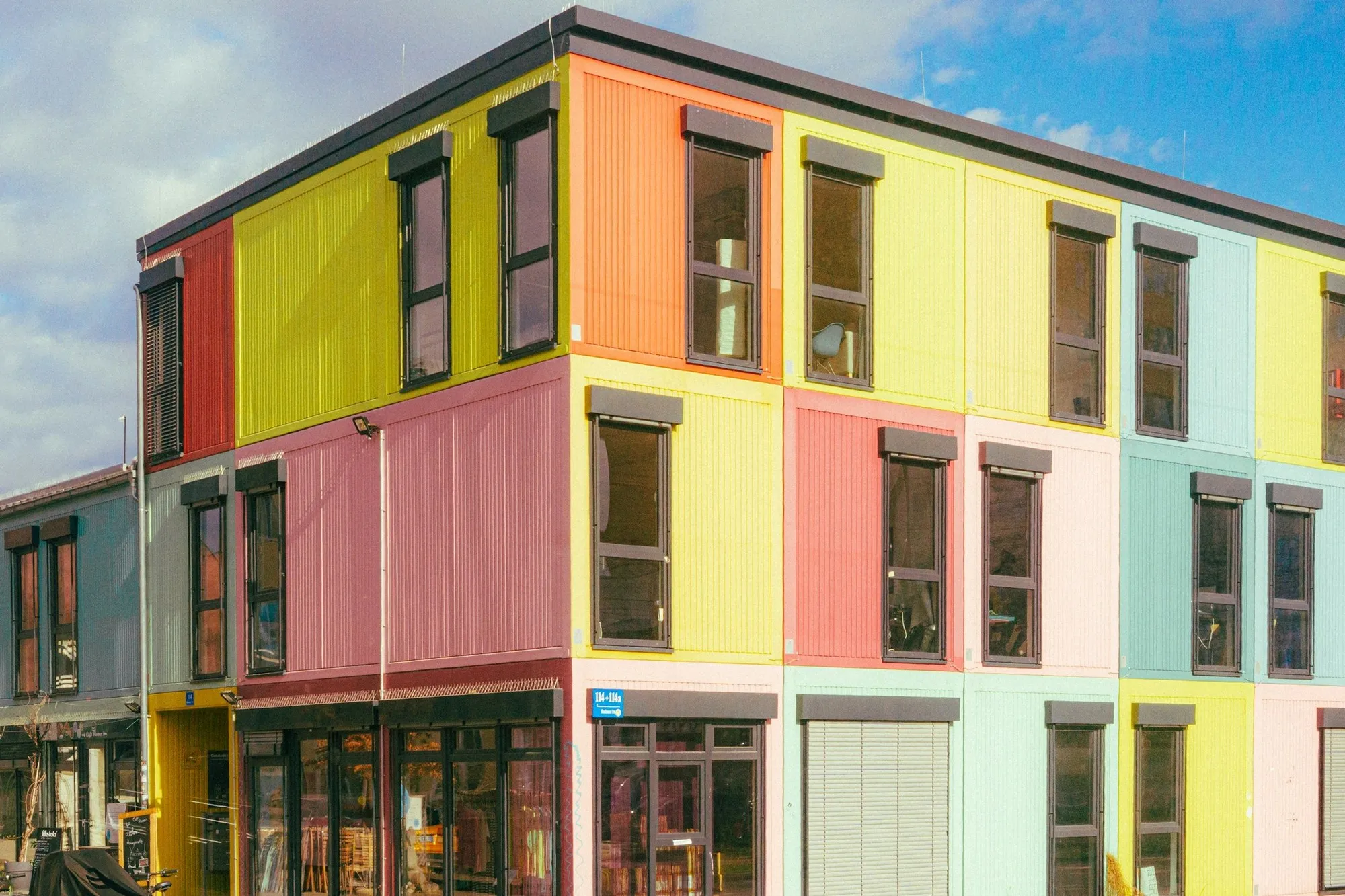 Two-storey modular building with colourful cladding panels and glazed ground floor
