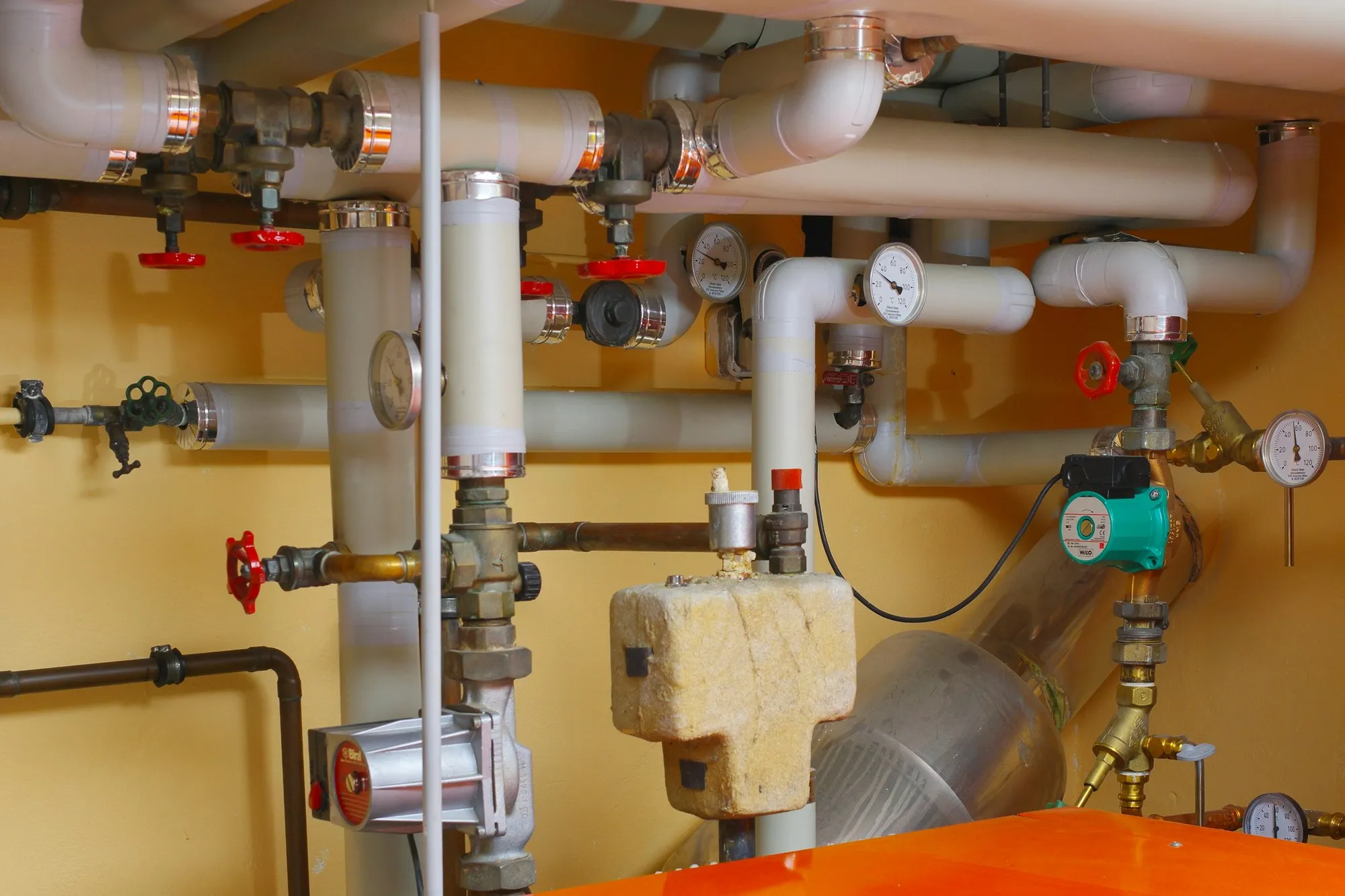 Boiler room with insulated pipework, valves, gauges and circulation pumps