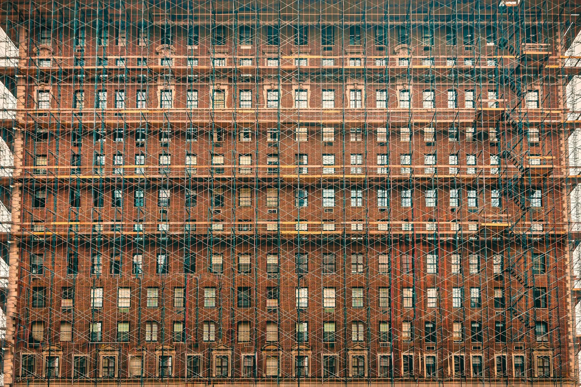 Brick apartment block wrapped in scaffolding for external works