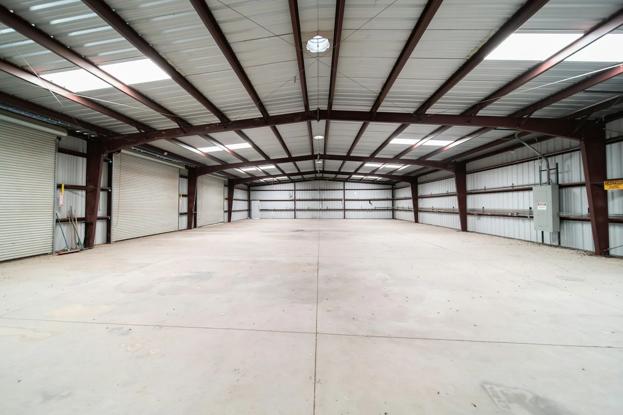 Empty steel-framed warehouse with clean concrete slab and roof lights