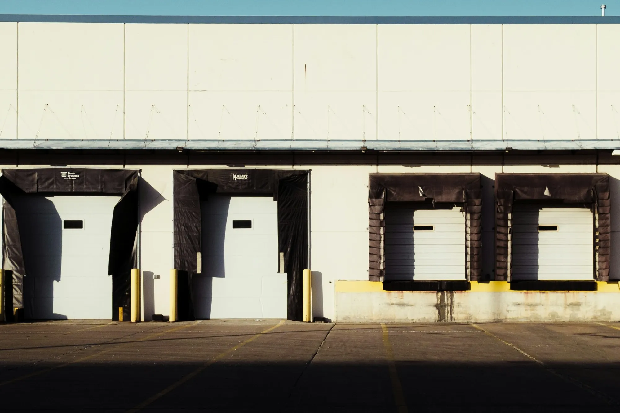 Loading dock bays with dock shelters on a pale warehouse wall