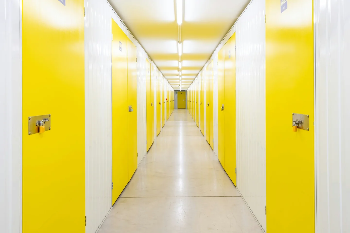 Self storage corridor lined with bright yellow unit doors