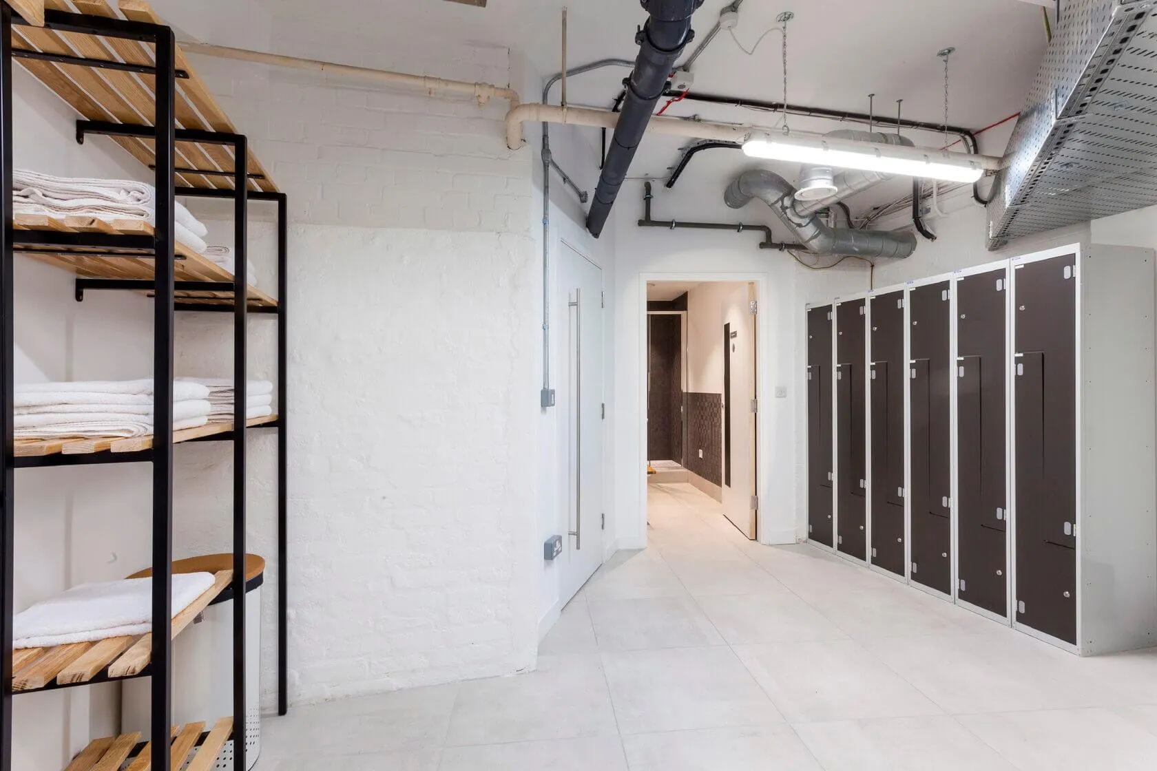 Showers and lockers with exposed ductwork at Portsoken House