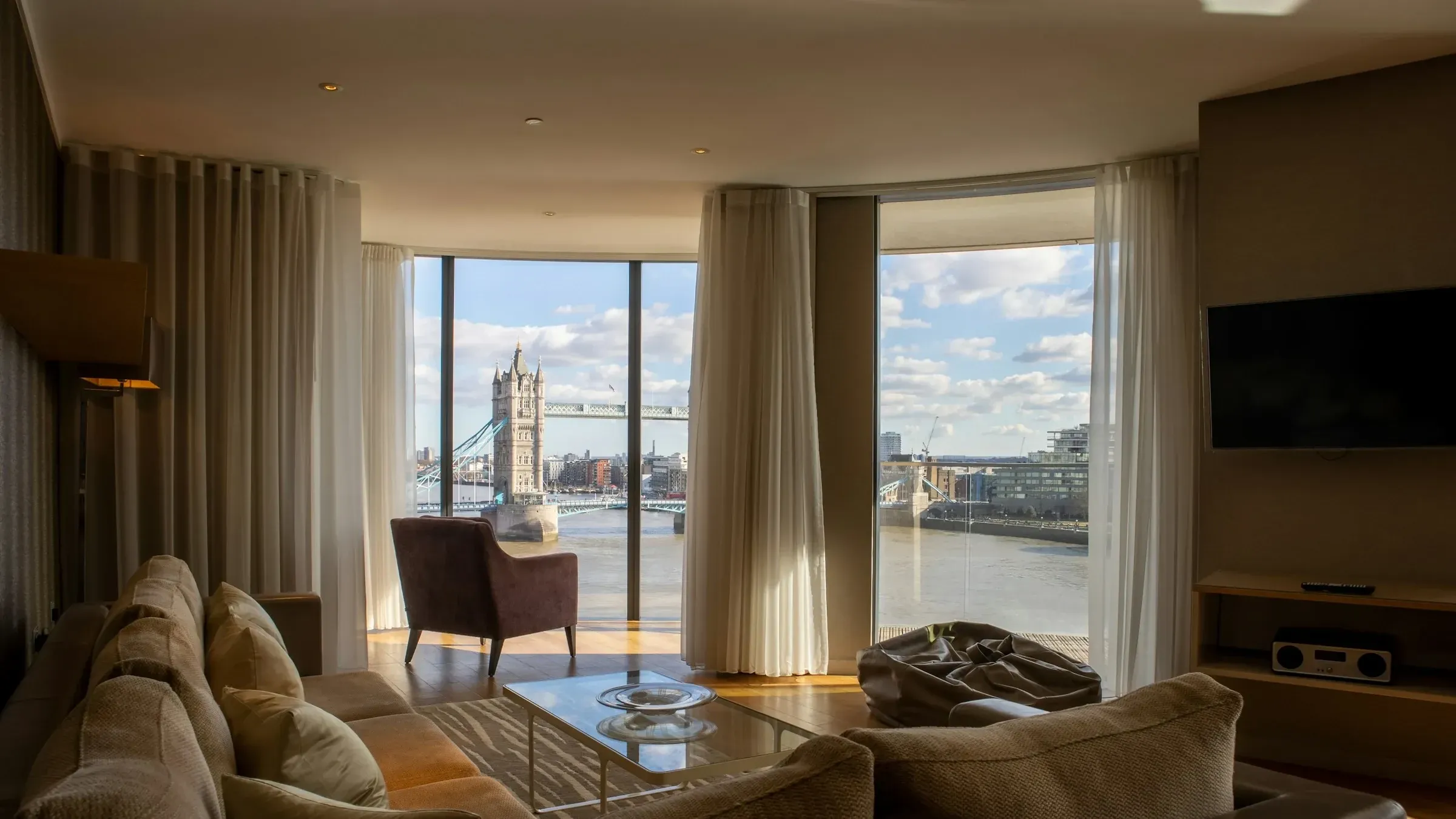 Finished London apartment living room with full-height windows looking out to Tower Bridge and the Thames