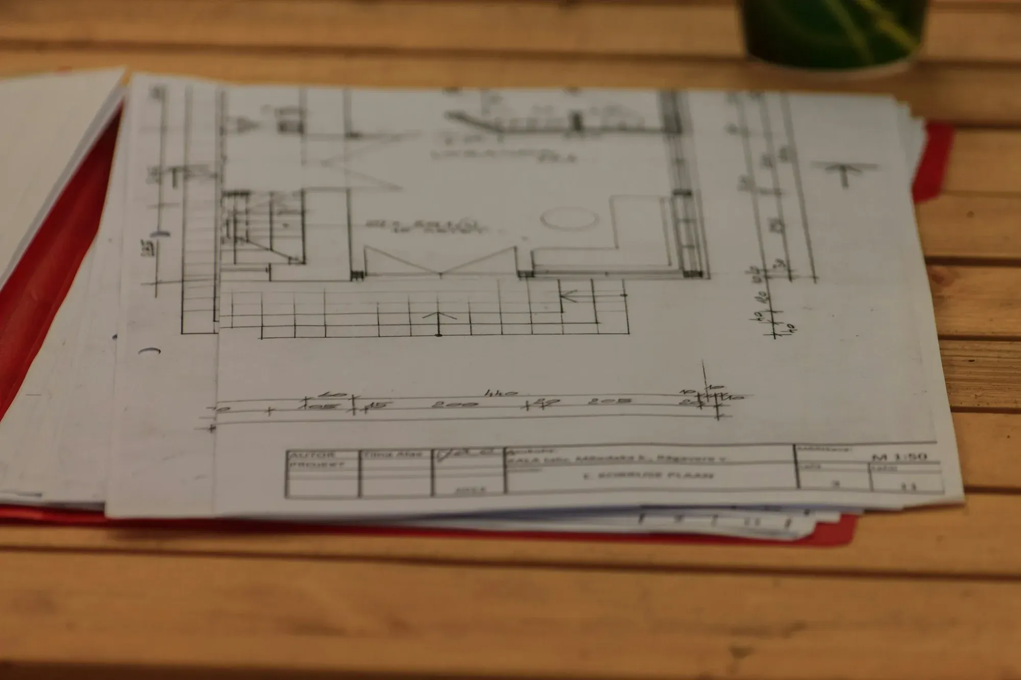 Printed floor plans and sketch drawings spread on a wooden table