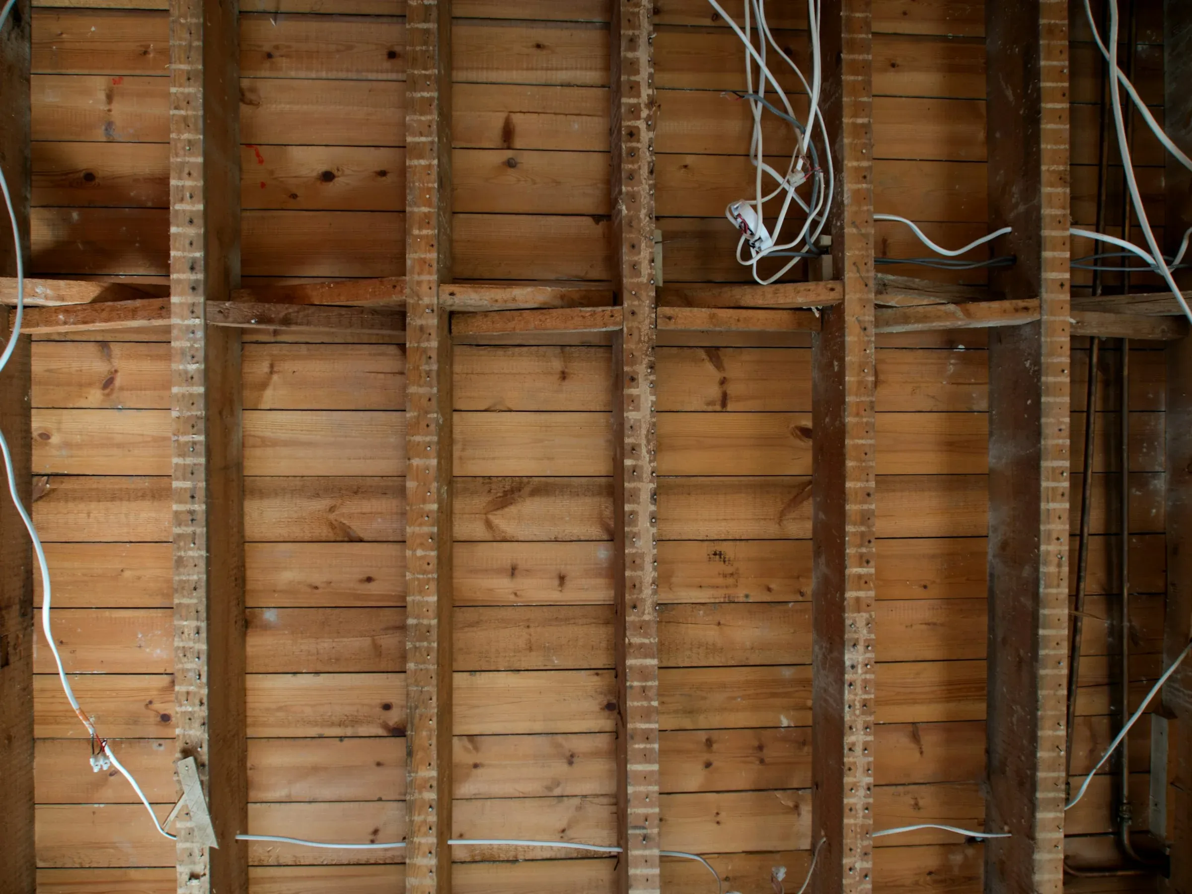 Timber studwork and boarding with loose electrical cables before the wall is closed up