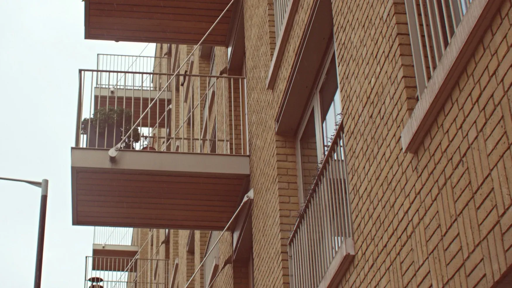 Balconies and brick external wall of a London apartment block seen from the street
