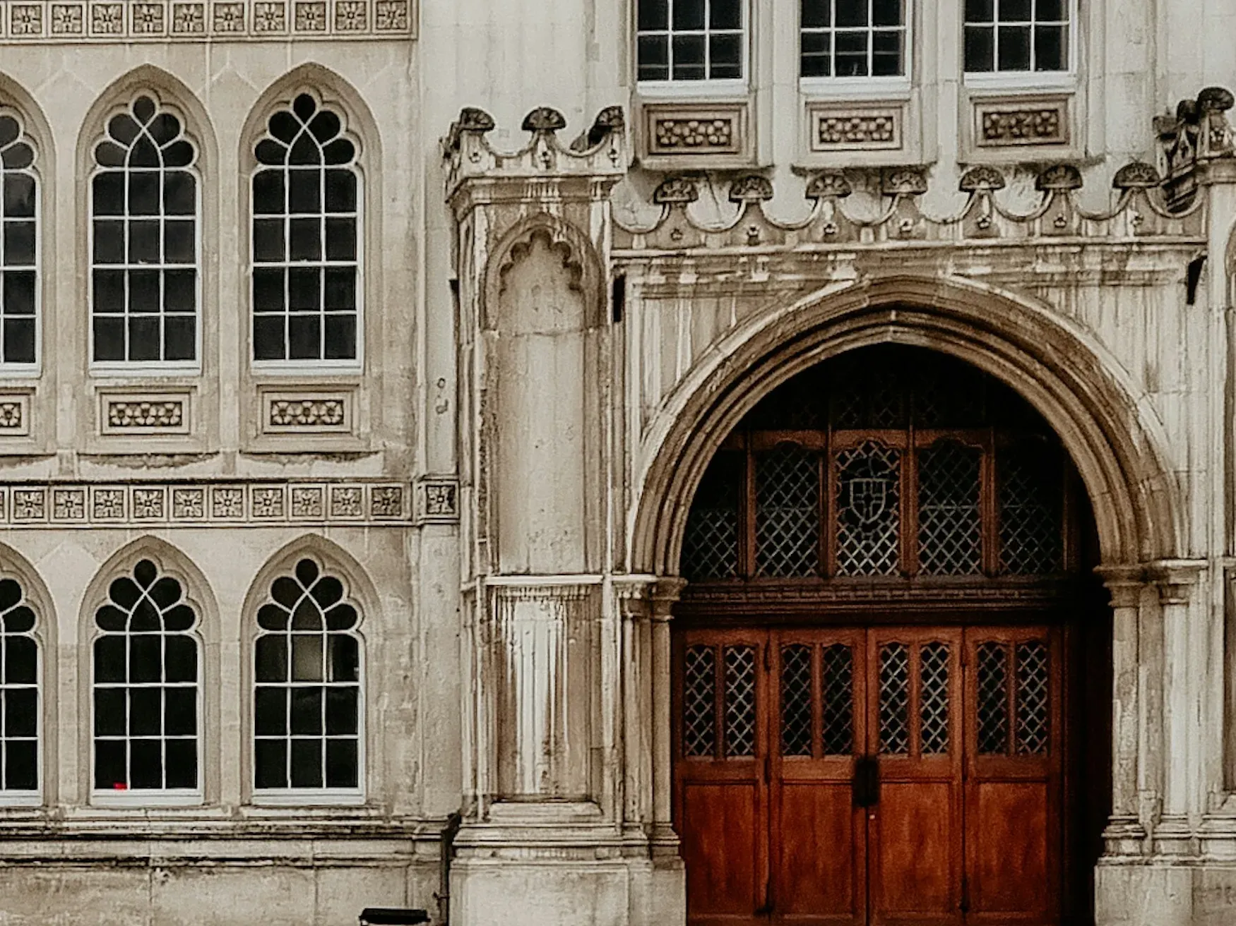Gothic stone façade and oak doors of Guildhall, the City of London Corporation's civic seat