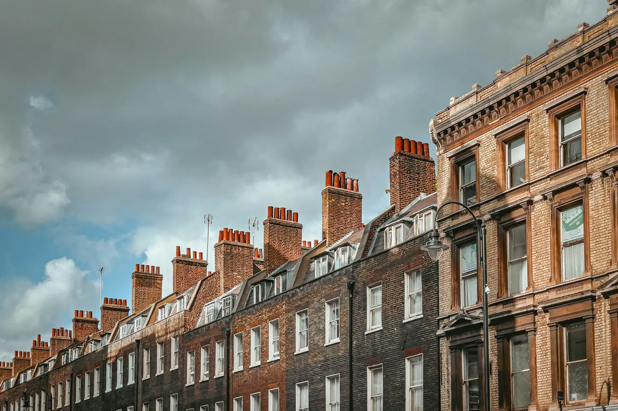 Georgian brick terrace with chimney stacks under a cloudy sky