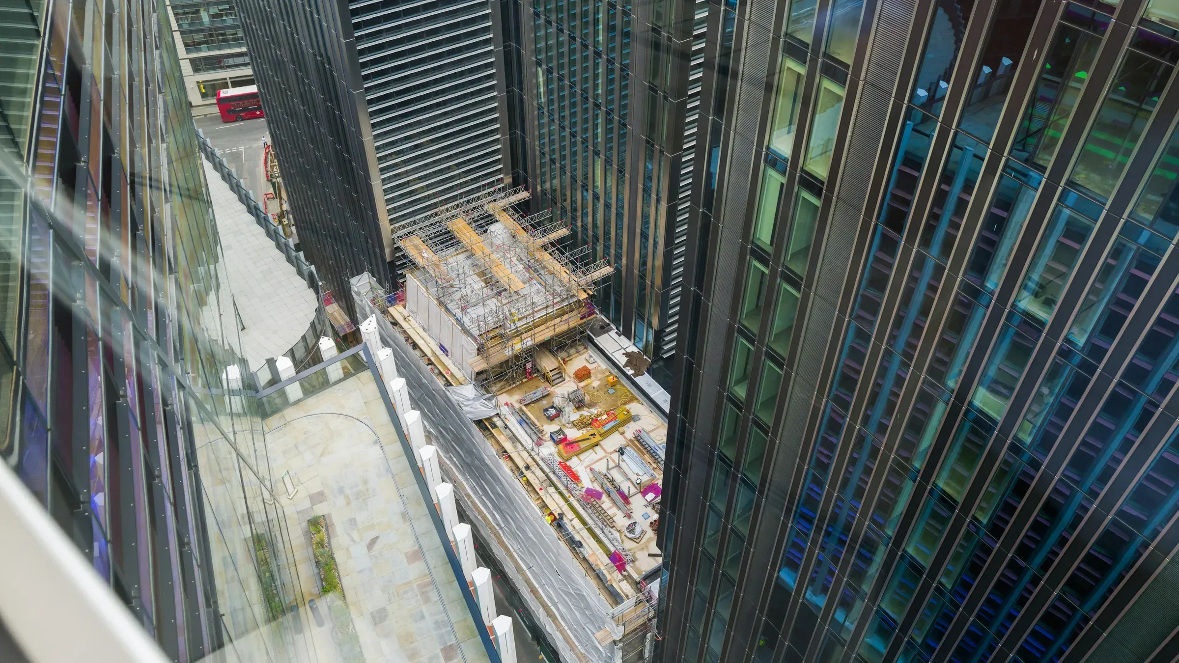 City of London construction site seen from above through the glazing of a neighbouring office tower