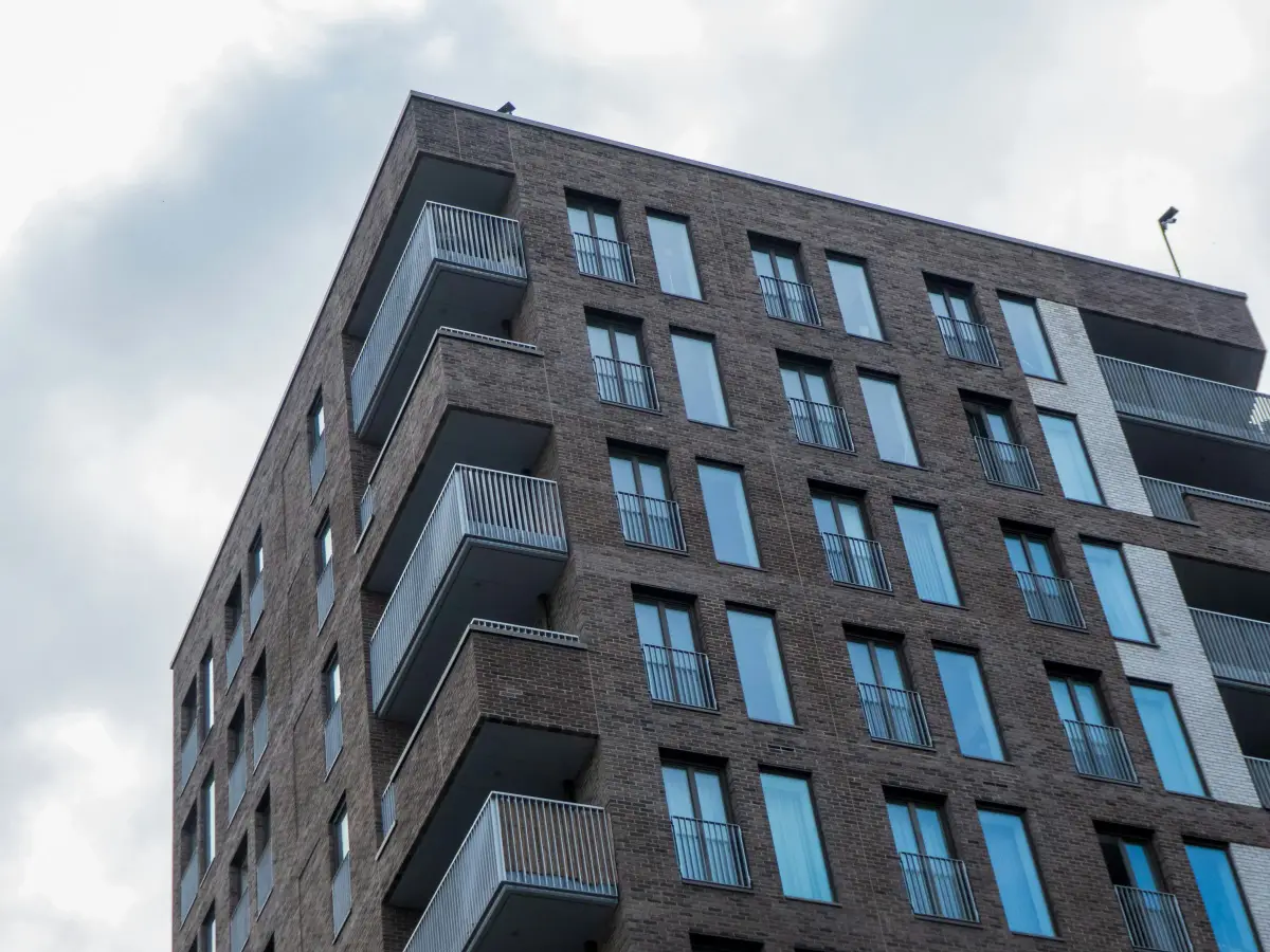 Brick apartment block with balconies in Farringdon, London, against a cloudy sky