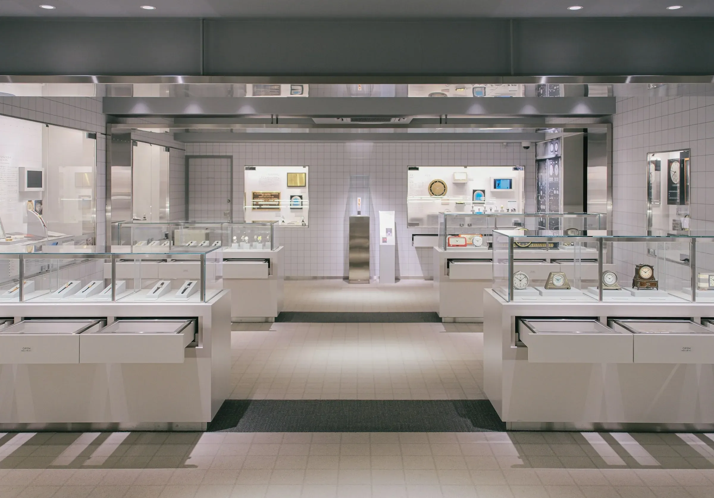 Bright showroom with white display counters, glass cases and recessed ceiling lights