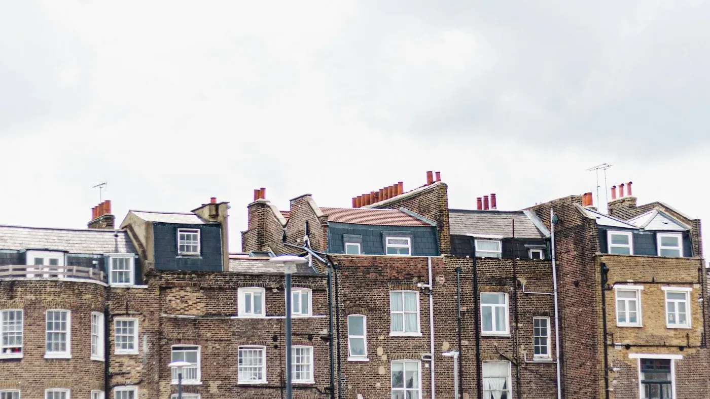 Rear roofline of London brick terraces with slate mansards, dormers and chimney pots