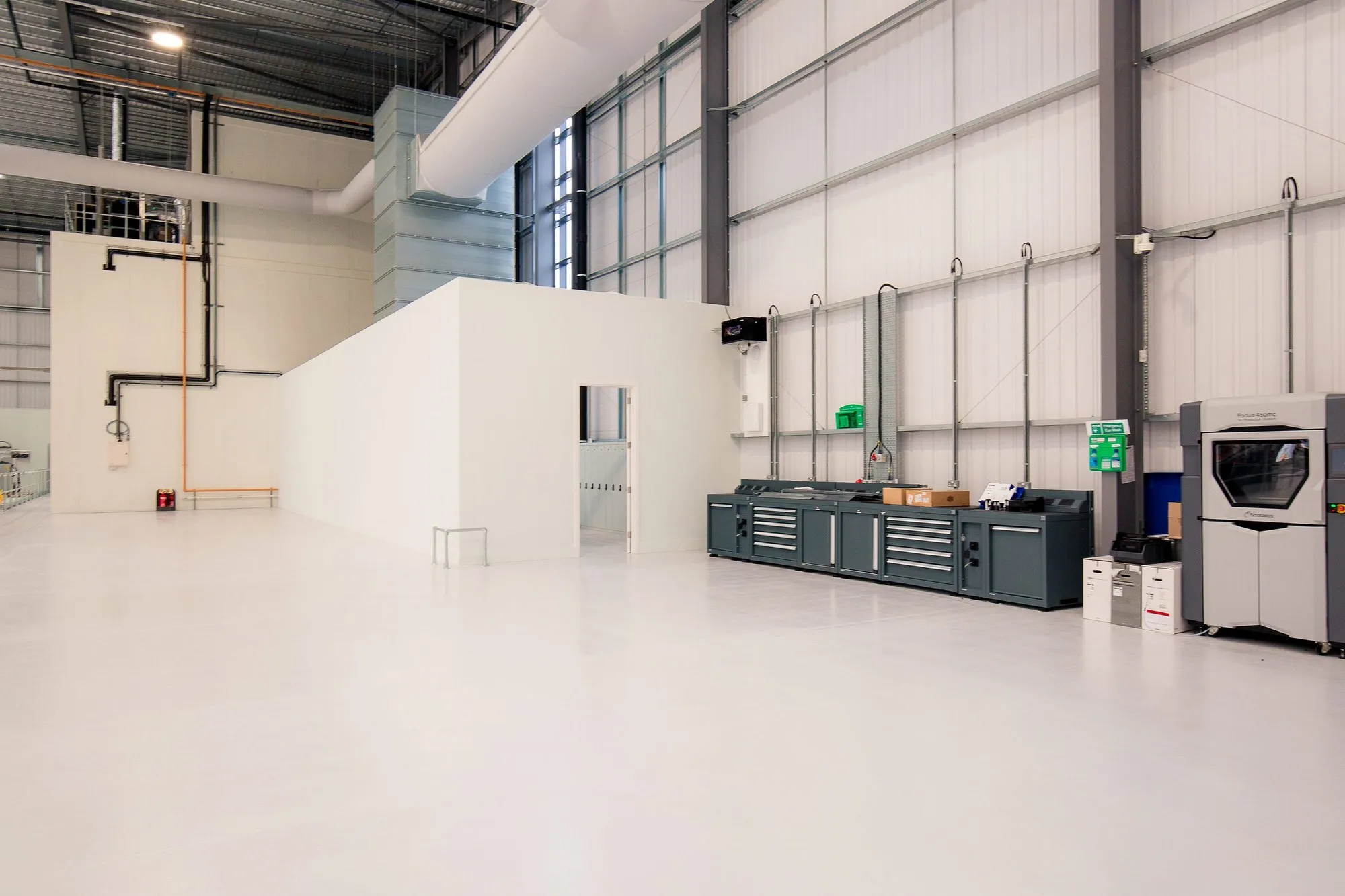 Banbury warehouse after the fit-out: a new block, ventilation ductwork, services and workshop benches on a resin floor