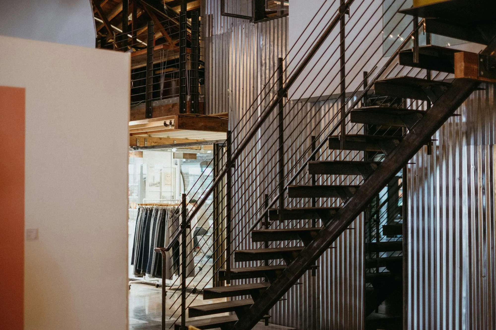 Steel staircase with slim balustrade rising to a mezzanine in a warehouse