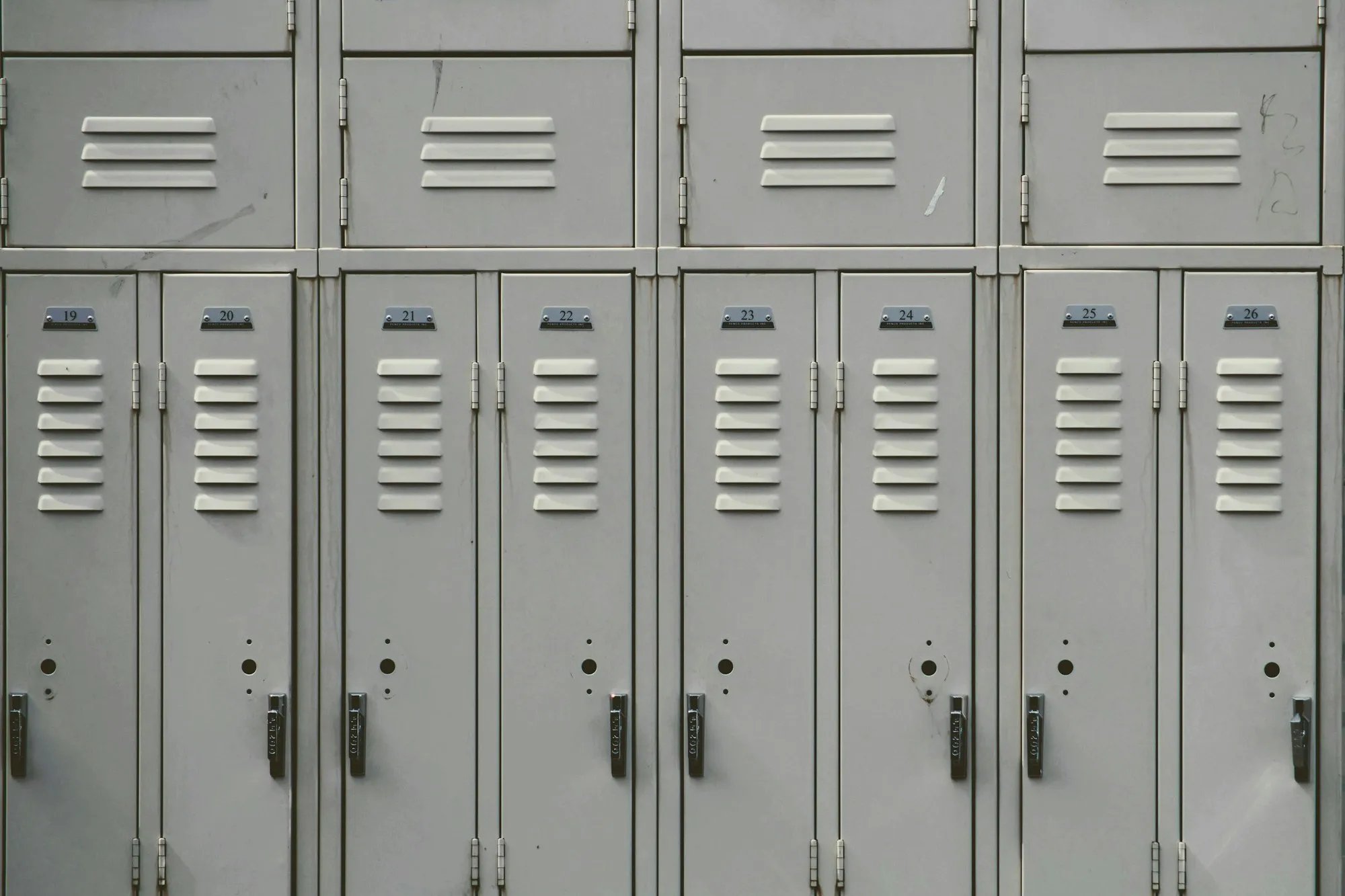 Rows of grey metal lockers with louvred doors