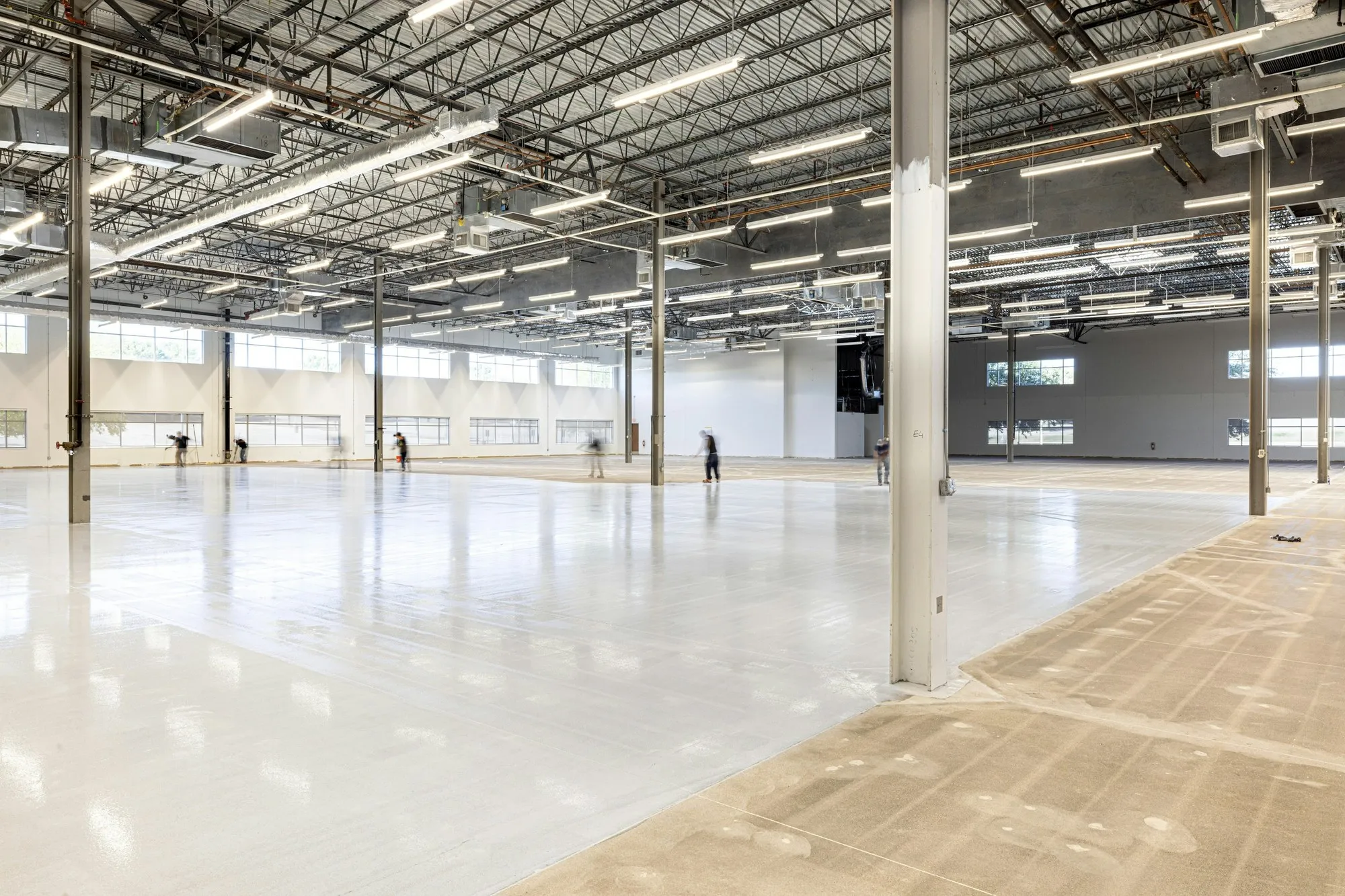 Large bright warehouse with a pale resin floor and high steel roof