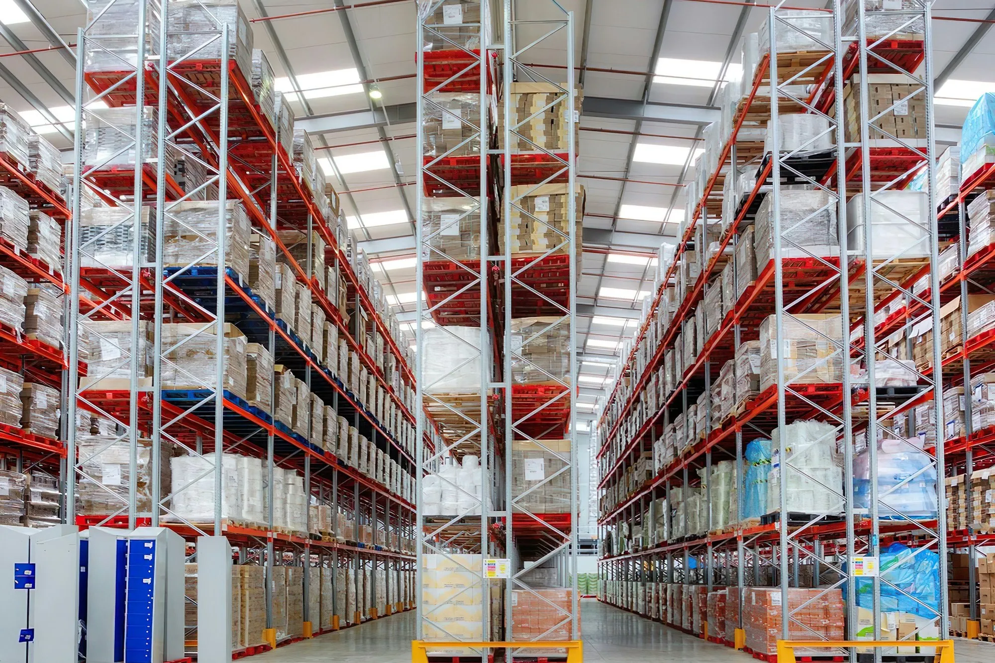 Tall pallet-racking aisle under bright warehouse lighting